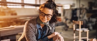 female working on blueprints in factory