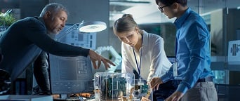 team of business people analyzing a mechanical model on a desk